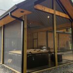 Side view of hot tub area enclosed with Mountain View Screens under a corrugated metal roof.