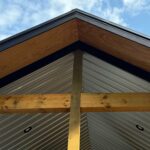 Close-up of corrugated metal patio ceiling with natural wood framing prior to screen enclosure.